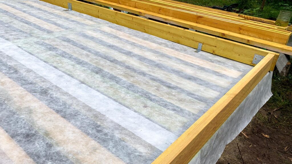Wooden beams frame a freshly laid vapor barrier, evoking the magic of constructions silent groundwork, akin to Archtobers architectural celebration