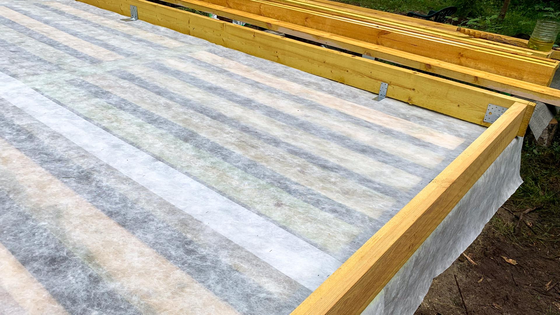 Wooden beams frame a freshly laid vapor barrier, evoking the magic of constructions silent groundwork, akin to Archtobers architectural celebration