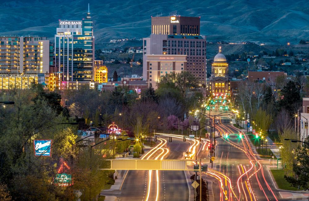 alden-skeie-cBx1EygM3BM-unsplash (1) A vibrant cityscape at night, illuminated by streetlights and glowing buildings, creating a lively urban atmosphere.